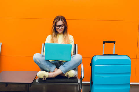 Young Girl With Long Hair Is Sitting Chair Orange Background She Wears Yellow Sweater Jeans She Is Typing Laptop